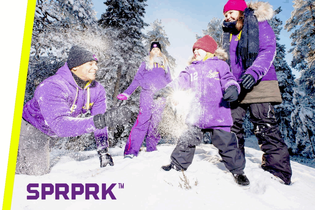 A family playing in the snow with the text SPRPRK™ in the corner